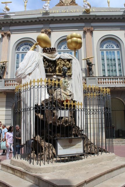 Inga surrealistiska happenings rapporterades från invigningen. Det fanns väl desto mer av sådant inne i museet. Den inhägnade statyn är en hyllning till de katalanska filosoferna Francesc Pujols och Ramom Llull.